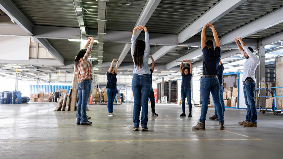 Mitarbeiter der Industrie machen ergonomische Übungen 