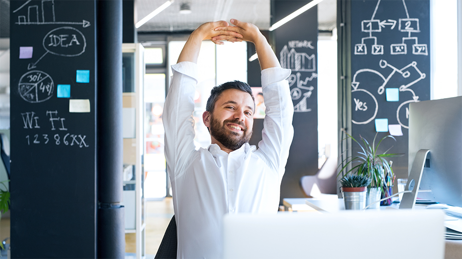 Mitarbeiter im Büro macht Stretching, um das Gesundheitsbewusstsein zu stärken und Stressprävention zu betreiben.