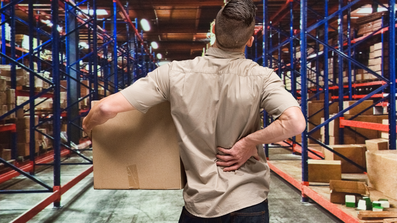 Produktionsmitarbeiter hat Rückenschmerzen: effektive Prävention von Rückenschmerzen und Gelenkbeschwerden im Fertigungsbereich ist unabdingbar.