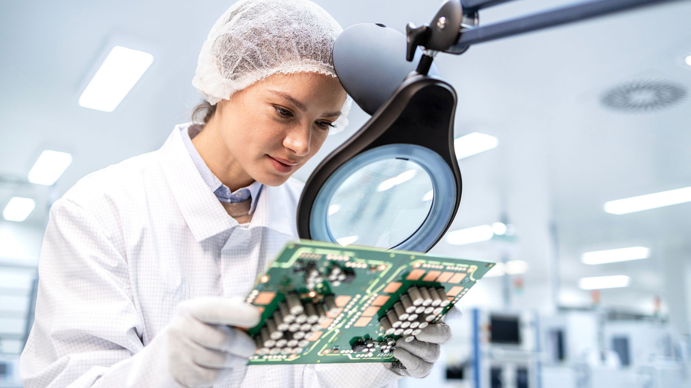 Mitarbeiterin arbeitet an einem ESD-geschützten Arbeitsplatz in der Elektroproduktion.